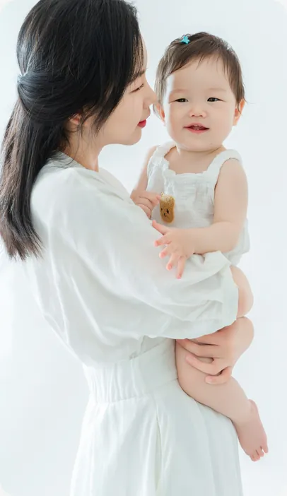 Candace holding her daughter, both in white
